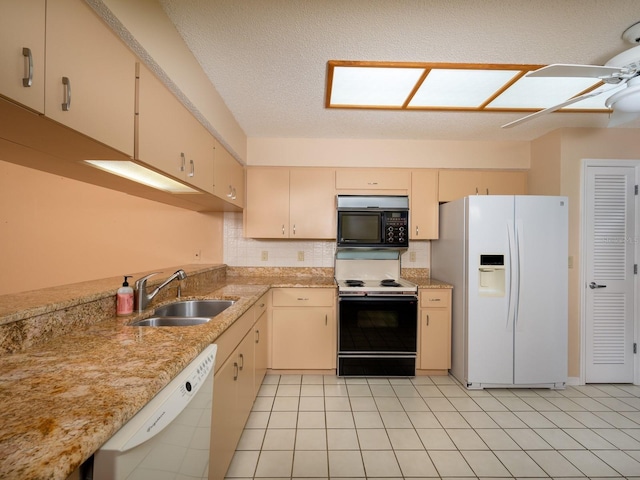 kitchen with a textured ceiling, sink, white appliances, and cream cabinetry