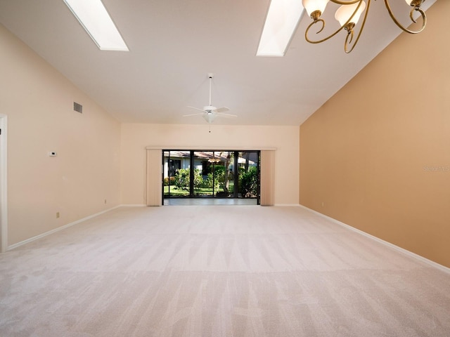 unfurnished living room with light carpet, ceiling fan with notable chandelier, and high vaulted ceiling