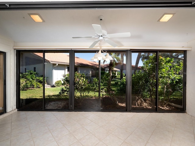 unfurnished sunroom with ceiling fan