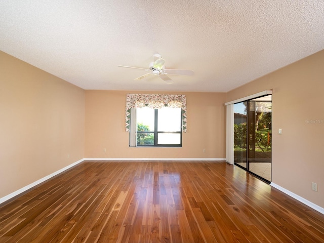 empty room featuring ceiling fan, dark hardwood / wood-style flooring, and a textured ceiling