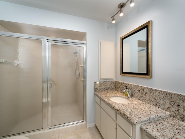 bathroom featuring tile patterned floors, a shower with door, and vanity