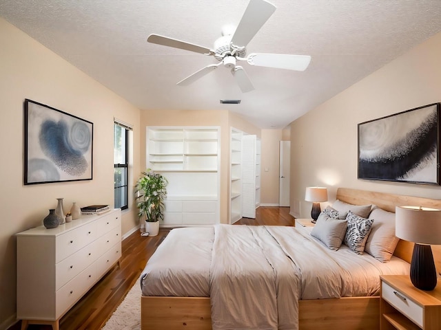 bedroom with ceiling fan, wood-type flooring, and a textured ceiling