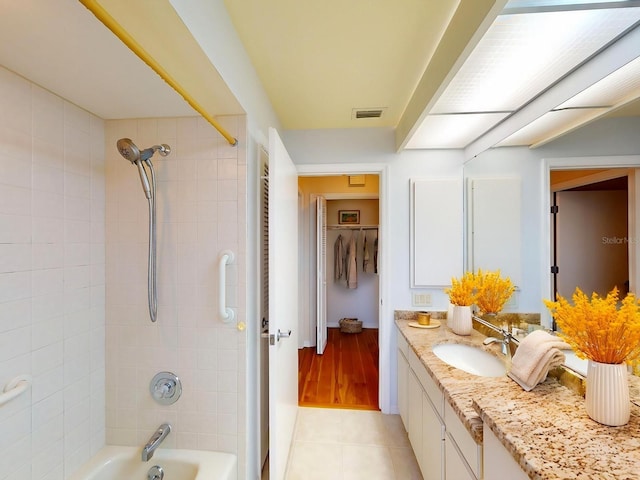 bathroom with tile patterned floors, tiled shower / bath combo, and vanity