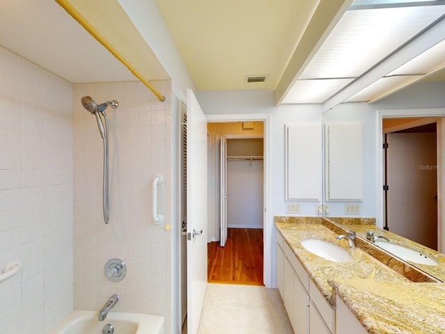 bathroom with tile patterned floors, vanity, and tiled shower / bath