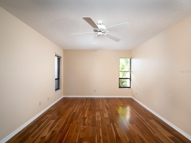 unfurnished room with a textured ceiling, dark hardwood / wood-style floors, and ceiling fan