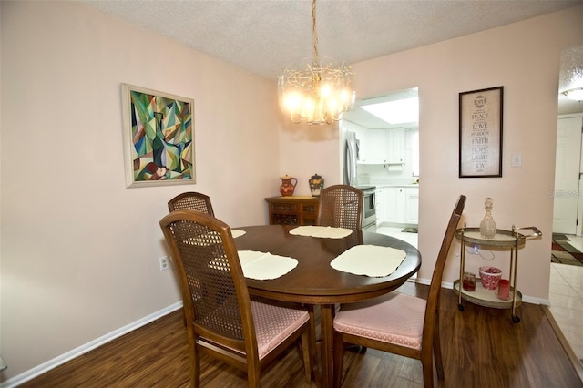 dining room with a notable chandelier, a textured ceiling, and dark wood-type flooring