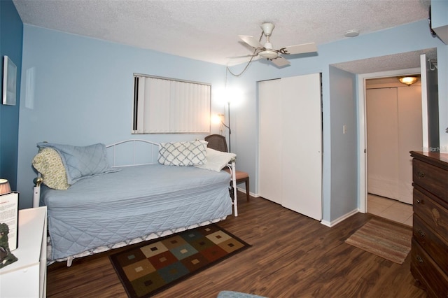 bedroom featuring ceiling fan, dark hardwood / wood-style flooring, and a textured ceiling