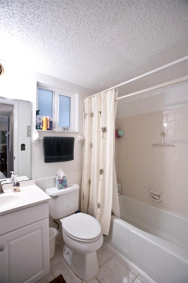 full bathroom featuring shower / bath combo, tile patterned floors, a textured ceiling, toilet, and vanity