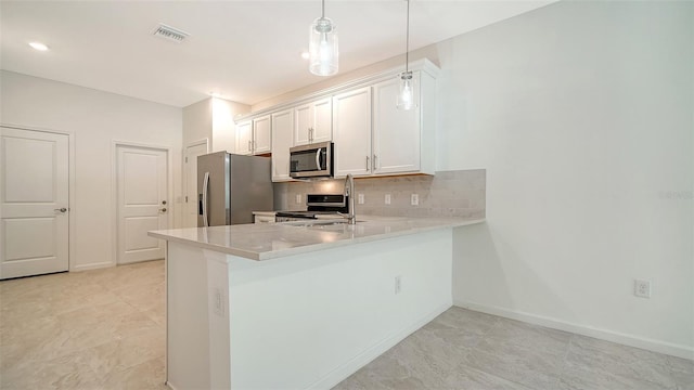 kitchen with backsplash, white cabinets, appliances with stainless steel finishes, decorative light fixtures, and kitchen peninsula