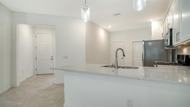 kitchen featuring sink, stainless steel appliances, kitchen peninsula, pendant lighting, and white cabinets