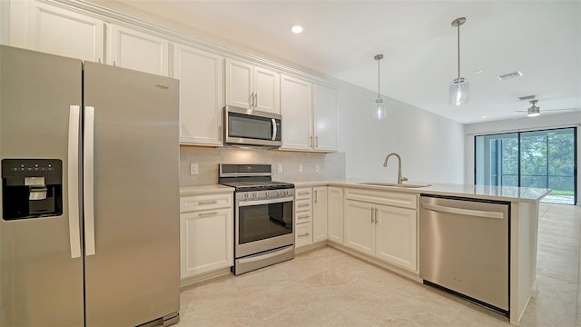 kitchen with white cabinets, kitchen peninsula, sink, and appliances with stainless steel finishes