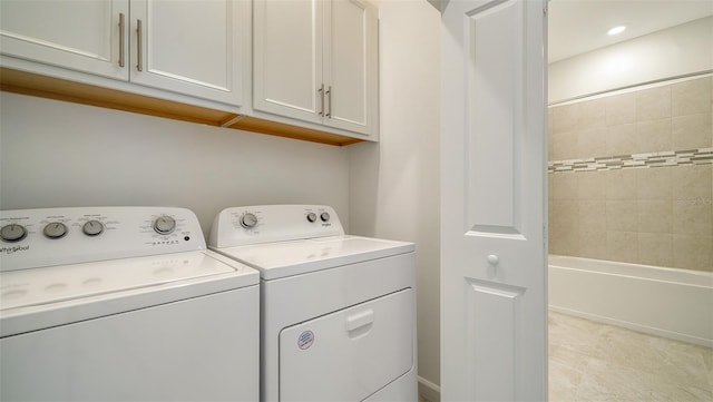 laundry room featuring washing machine and dryer and cabinets