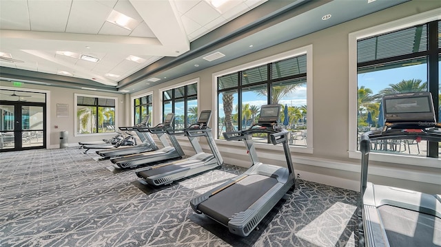 exercise room with plenty of natural light and dark carpet