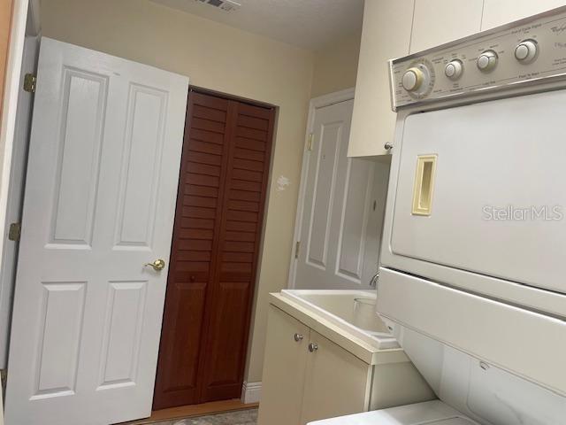 laundry area with stacked washing maching and dryer