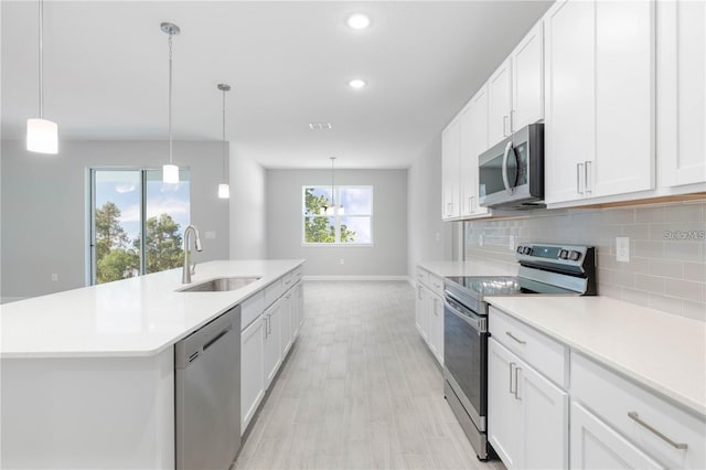 kitchen with a wealth of natural light, sink, white cabinets, and stainless steel appliances