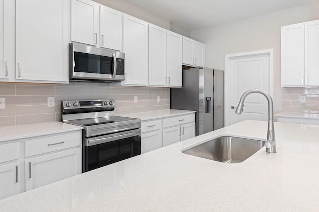 kitchen with white cabinets, appliances with stainless steel finishes, backsplash, and sink