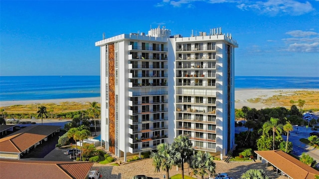 view of building exterior featuring a beach view and a water view