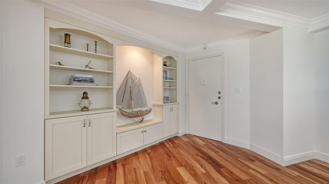 mudroom with built in features, light hardwood / wood-style flooring, and crown molding