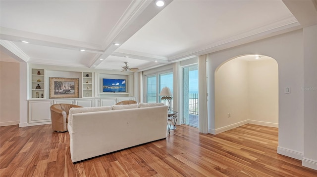 living room featuring beamed ceiling, ceiling fan, light hardwood / wood-style floors, and crown molding