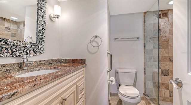 bathroom with a shower with door, vanity, and toilet