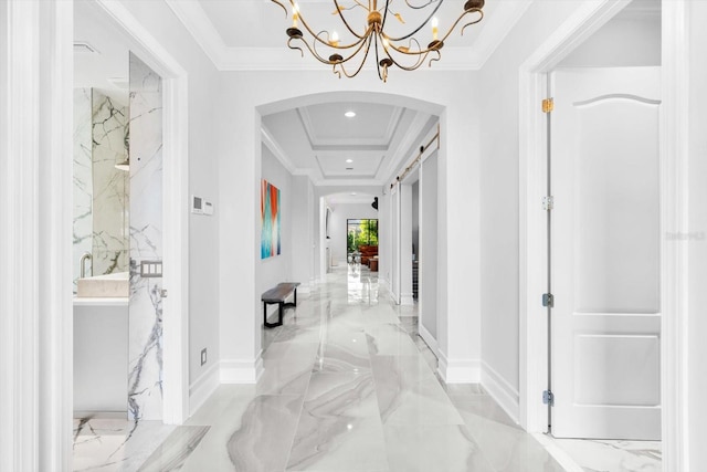 hallway featuring ornamental molding and a barn door