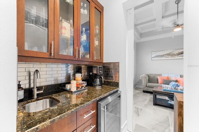 bar with tasteful backsplash, dark stone counters, beverage cooler, and sink