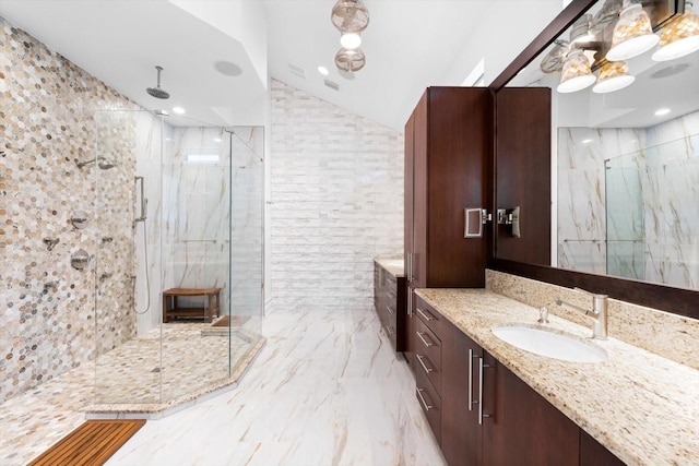 bathroom featuring vanity, lofted ceiling, and tiled shower