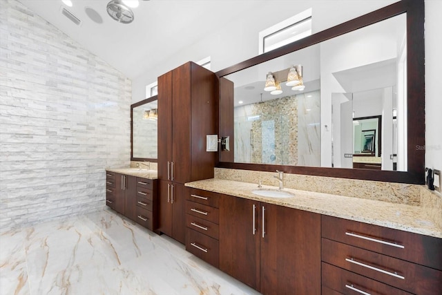 bathroom with lofted ceiling, vanity, and a shower with door