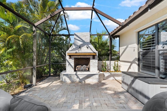 view of patio with an outdoor stone fireplace and glass enclosure