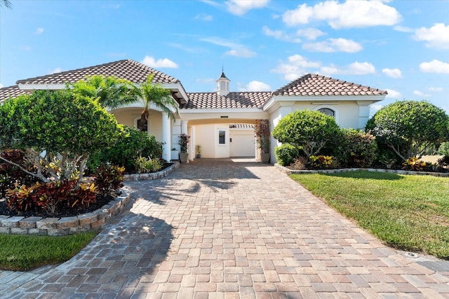 mediterranean / spanish-style house featuring a garage and a front lawn