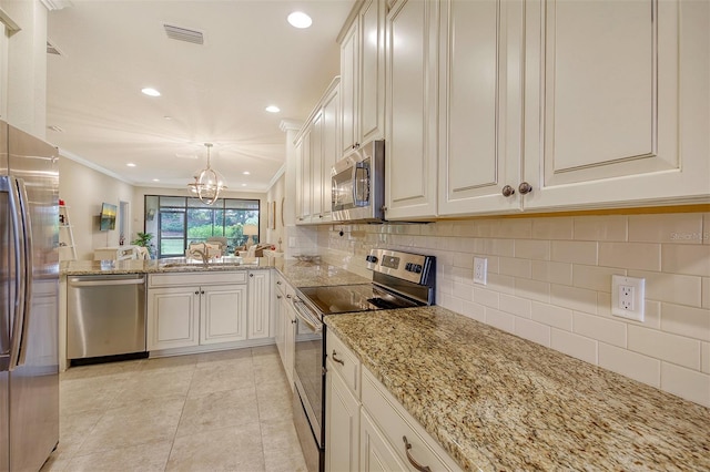 kitchen with white cabinetry, hanging light fixtures, stainless steel appliances, crown molding, and a chandelier