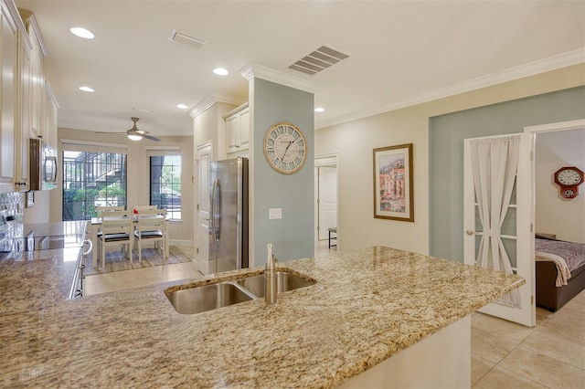 kitchen featuring light stone countertops, sink, ceiling fan, stainless steel appliances, and crown molding