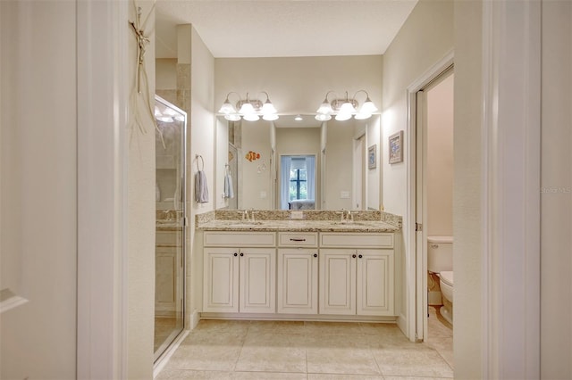 bathroom with tile patterned flooring, vanity, a shower with door, and toilet