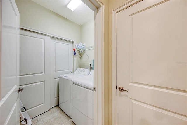 laundry room with washing machine and dryer and light tile patterned floors