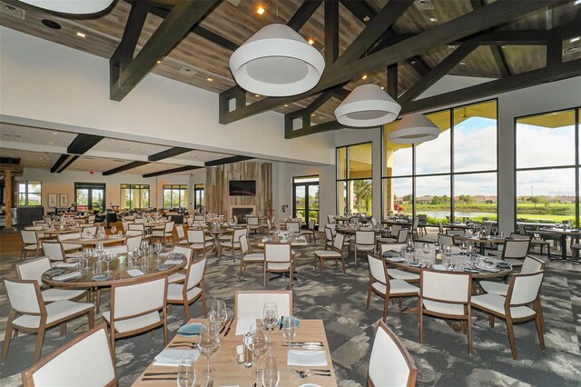 dining space featuring beam ceiling and a high ceiling