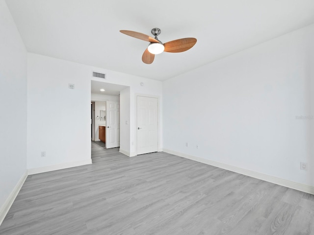 empty room with ceiling fan and light hardwood / wood-style floors