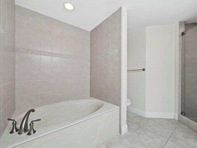 bathroom with tile patterned flooring, toilet, and plus walk in shower