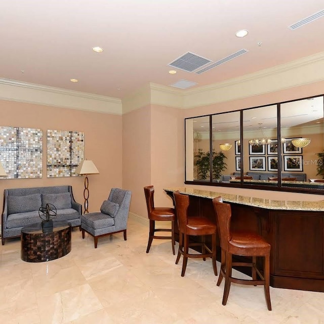 bar with light stone counters and crown molding