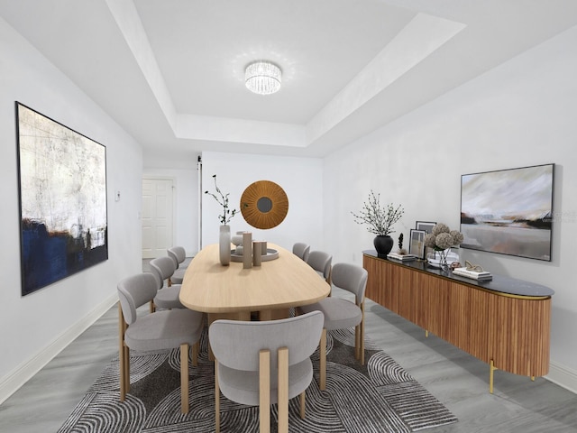 800 N Tamiami Trl Unit 307, Sarasota, FL 34236 - dining area featuring baseboards, light wood-style floors, and a raised ceiling