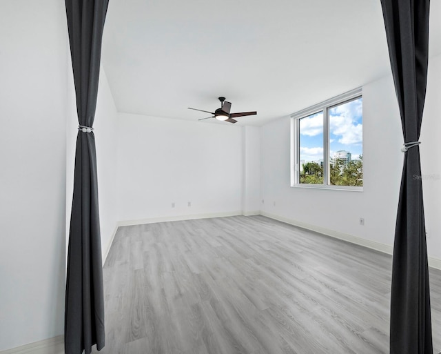 800 N Tamiami Trl Unit 307, Sarasota, FL 34236 - unfurnished room with light wood-style floors, a ceiling fan, and baseboards
