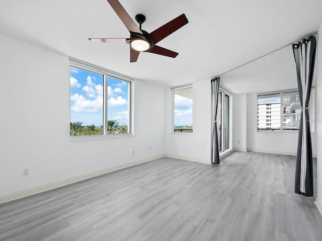 unfurnished room with ceiling fan and light wood-type flooring