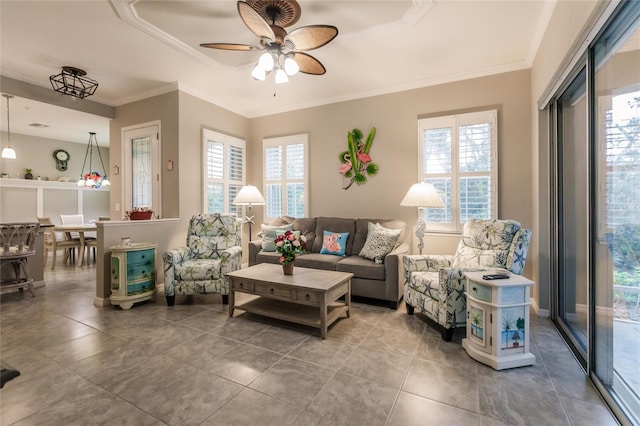 living room featuring ceiling fan, plenty of natural light, and crown molding