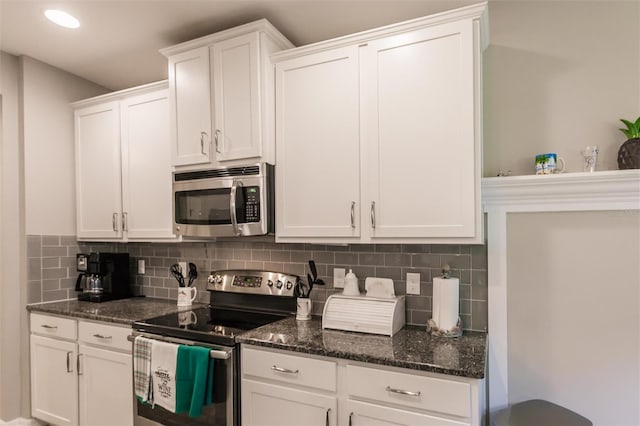 kitchen with decorative backsplash, white cabinetry, dark stone countertops, and appliances with stainless steel finishes