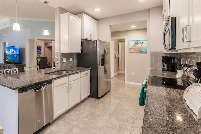 kitchen featuring sink, hanging light fixtures, dark stone countertops, white cabinetry, and stainless steel appliances