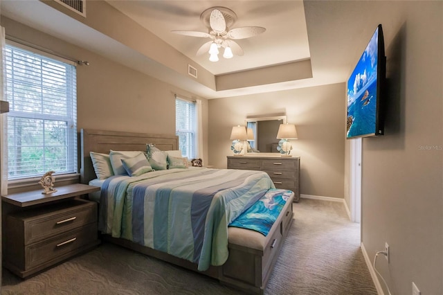 bedroom with dark carpet, multiple windows, and ceiling fan