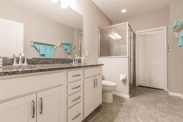 bathroom featuring tile patterned floors, vanity, toilet, and walk in shower