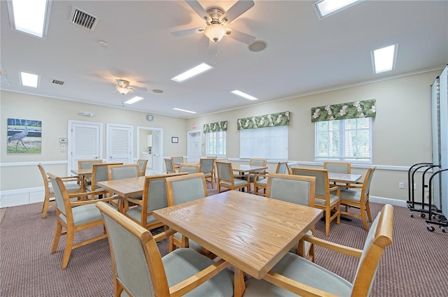 carpeted dining room with ceiling fan