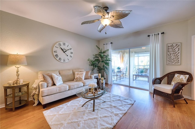 living room with ceiling fan and light hardwood / wood-style floors