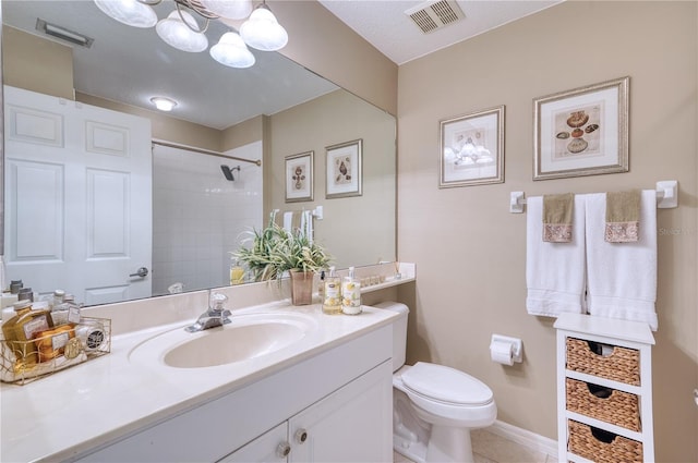 bathroom with toilet, vanity, tile patterned flooring, tiled shower, and a textured ceiling