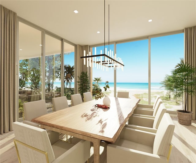 dining room with floor to ceiling windows, a water view, light wood-type flooring, and a beach view